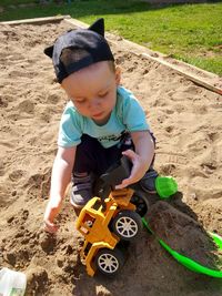 High angle view of boy playing with construction toys in sandbox at playground