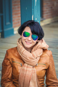 Woman wearing sunglasses sitting outdoors