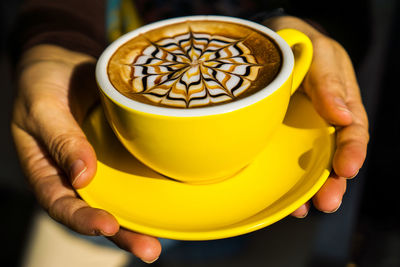 Close-up of hand holding coffee cup