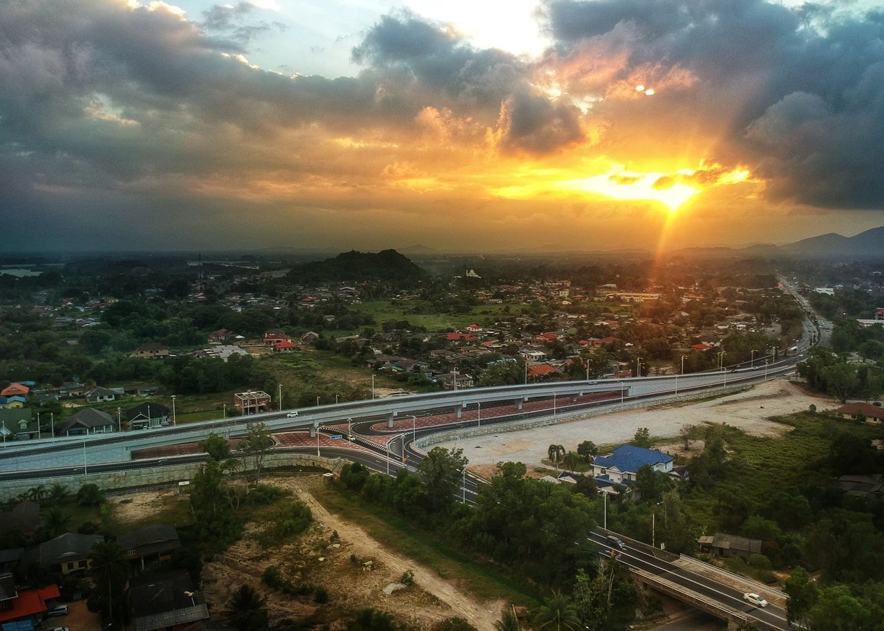 HIGH ANGLE VIEW OF CITYSCAPE AGAINST SKY AT SUNSET