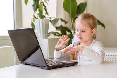 The girl learns, communicates, talks, through a computer / laptop