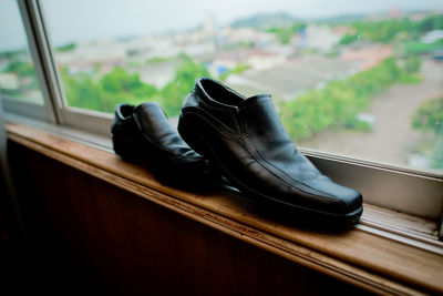 Close-up of black shoes on window