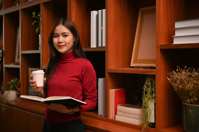 Portrait of young woman reading book