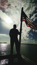 Silhouette man standing by sea