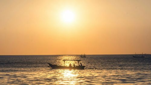 Silhouette boat in sea against sky during sunset