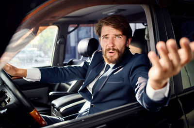 Portrait of angry businessman sitting in car