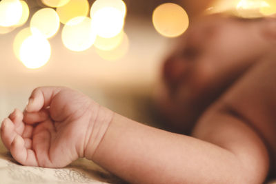 Cropped image of baby on bed at home