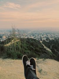 Low section of person in city against sky