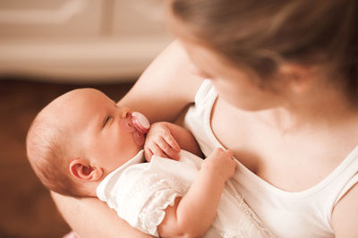 High angle view of mother carrying daughter at home