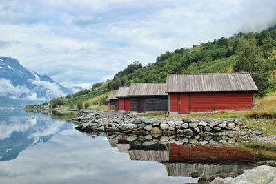 Houses by lake against sky