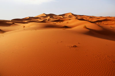 Sand dunes in desert against clear sky