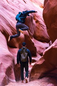 Man jumping over friend at canyon