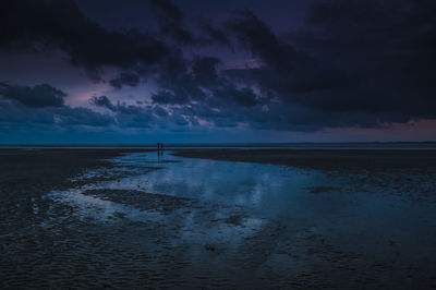 Scenic view of calm sea against cloudy sky