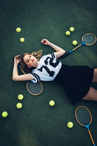 High angle view of tired young woman lying on court