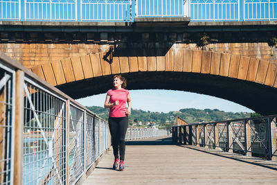 Woman standing on footbridge