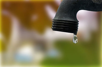Close-up of water drop hanging from faucet