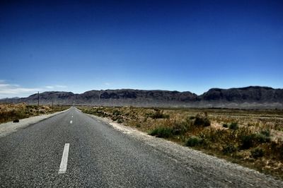 Empty road leading towards mountains