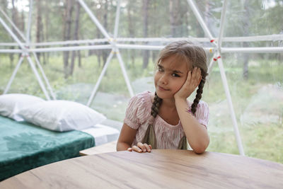 Portrait of girl sitting on table