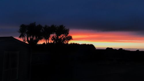 Silhouette trees against sky during sunset