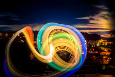 Light trails in city against sky at night