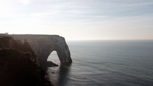 Rock formation in sea against sky