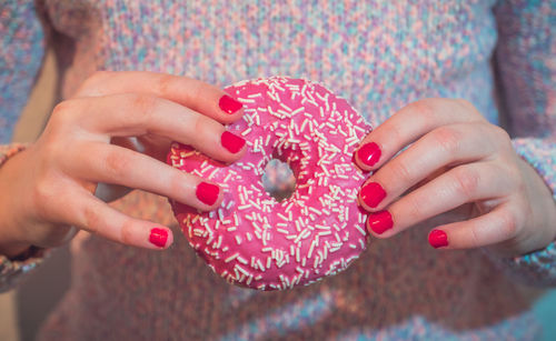 Midsection of woman holding donut at home