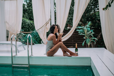 Woman sitting in swimming pool