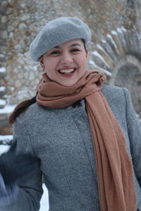 Portrait of smiling young woman standing in snow