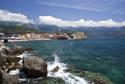 Scenic view of sea by buildings against sky