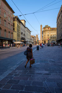 People walking on street amidst buildings in city