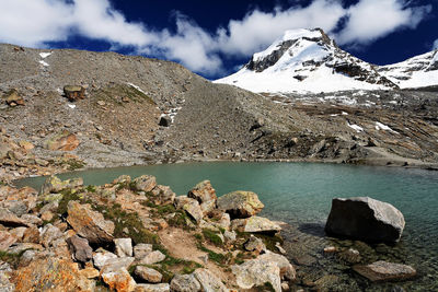 Scenic view of river by mountains against sky at gran paradiso national park