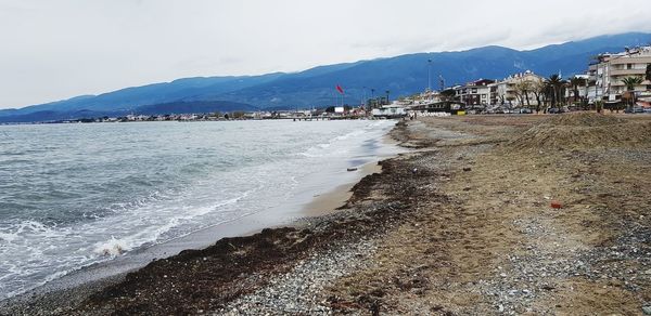 Scenic view of beach and buildings against sky