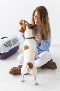 Young woman with dog sitting on floor