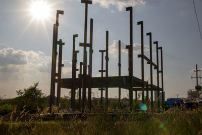 Low angle view of industry on field against sky