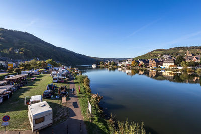 High angle view of townscape by lake against blue sky