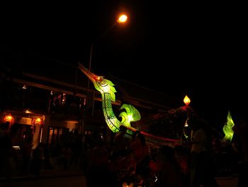 Crowd at illuminated music concert against sky at night