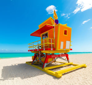 Lifeguard hut on beach against sky