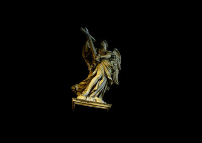 Low angle view of statue against black background