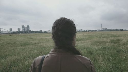 View of grassy field against cloudy sky