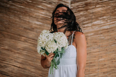 Midsection of woman holding flower bouquet