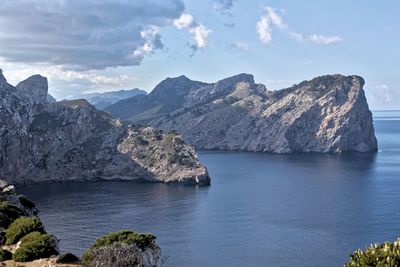 Scenic view of sea and mountains against sky