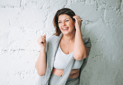Beautiful happy emotional brunette young woman plus size body positive in comfortable sport wear