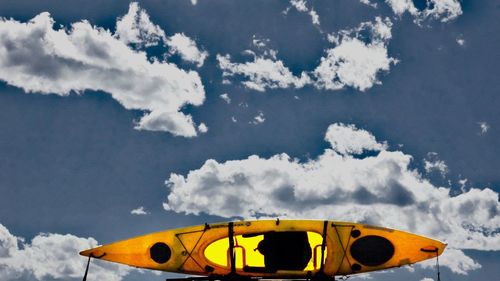 Low angle view of yellow umbrella against sky