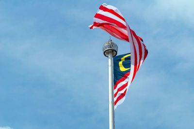 Low angle view of flag against blue sky