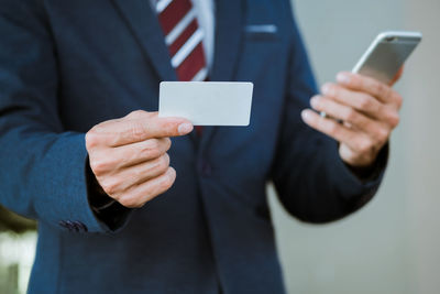 Midsection of man using mobile phone