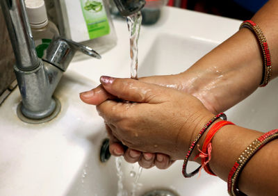 Cropped hands washing faucet