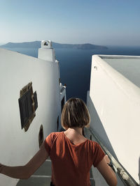 Rear view of boy looking at sea against sky
