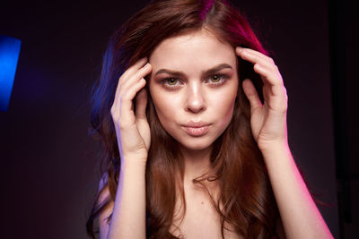 Portrait of a beautiful young woman over black background