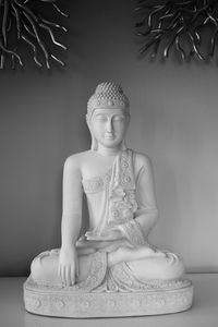 Low angle view of buddha statue against wall