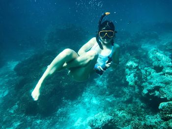 Portrait of woman swimming underwater in sea